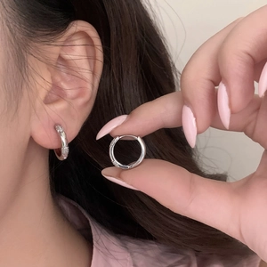 Boucles d'oreilles créoles en argent serties de zircons portées par un mannequin