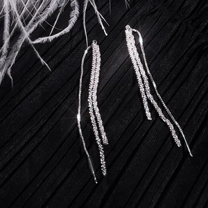 Elegant long silver tassel earrings with sparkling rhinestones on black pleated fabric
