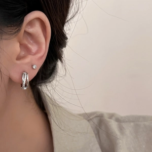 Ensemble de boucles d'oreilles minimalistes en argent avec zircons sur un modèle