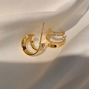 Elegant gold double hoop earrings with sparkling zircon crystals on white silk