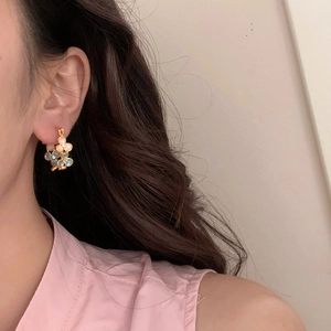 Boucles d'oreilles fleuries avec pétales nacrés bleu et blanc sur monture dorée