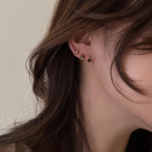 Gold plated hoop earrings with black zircon and small stud earring worn by a model