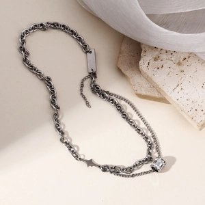 Close-up of double layer silver chain with sparkling zircon cylinder and star charms