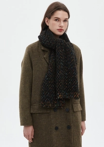 Detail of a thick black speckled knit scarf with multi-color flecks for winter warmth