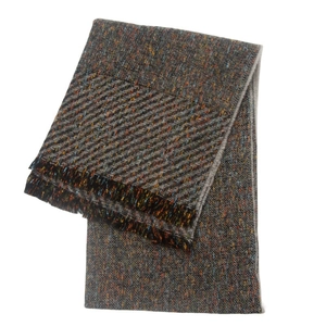 Close-up of dark grey herringbone scarf with colorful flecks and soft tassel edges