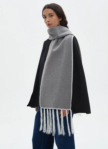 Detail of long grey winter scarf featuring white contrast stitching and long fringe tassels