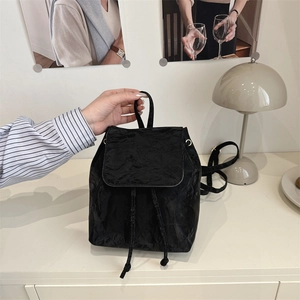 Chic black drawstring backpack with wrinkled texture and top handle for casual styling