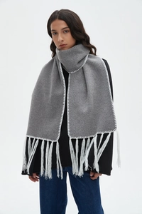 Detail of gray cashmere-feel scarf featuring contrast white hand-stitching and long tassels
