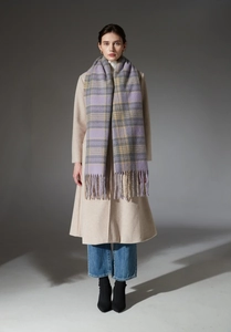 Detail of a thick purple and grey plaid scarf with soft tassels on a white winter coat