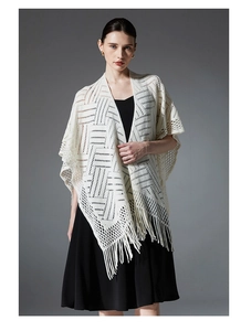 Vue détaillée du châle en tricot ajouré blanc crème avec des motifs et des franges