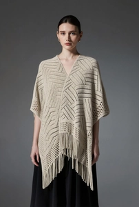Gros plan du châle beige au crochet avec motifs ajourés et longues franges élégantes