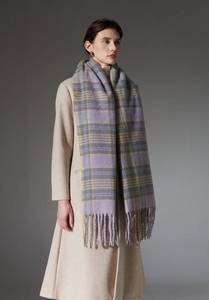 Detail of soft purple and yellow plaid scarf with long fringes on a beige wool coat