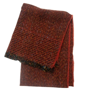 Detail of dark red mixed knit scarf showing thick fabric texture and black fringe edges