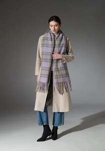 Macro detail of thick purple and grey plaid scarf with soft fringe on wool coat