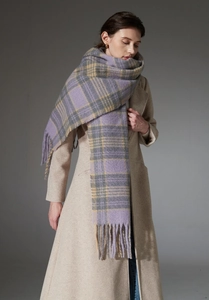 Detail of premium thick plaid scarf with tassels styled on a beige long woolen coat