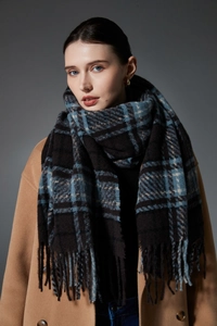 Detail eines weichen Karo-Schals mit langen Fransen in Blau und Beige für den Winter