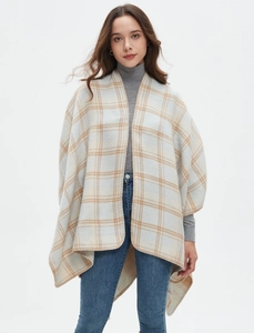 Detail of soft light blue plaid shawl texture and fine edge stitching on women's poncho
