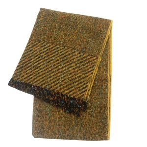 Detailed close-up of a thick knit yellow-green tweed scarf with colorful fringe tassels