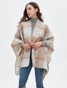 Detailed view of women's warm cashmere-like shawl with large beige plaid pattern