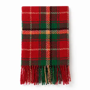 Detail of red and green plaid scarf featuring soft cashmere-like texture and long fringes
