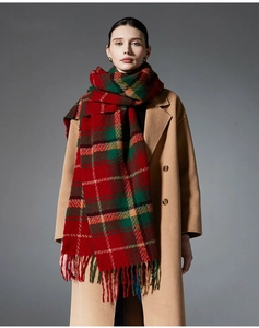 Detail shot of the red and green plaid scarf with fringe on a camel wool coat