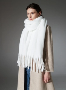 Detail of white chunky boucle scarf with long fringe tassels and fuzzy mohair texture