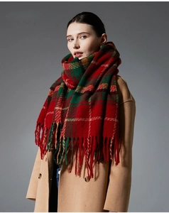 Close-up of red and green plaid scarf texture and long tassels on a wool blend shawl