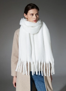 Detailed view of white oversized scarf with long tassels and soft mohair texture