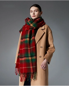 Close-up of red and green plaid scarf with long tassels and thick wool texture fabric