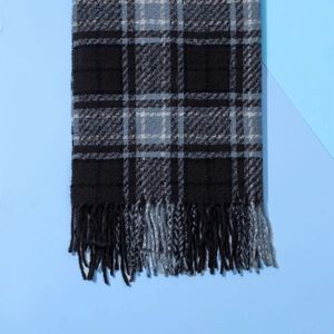 Detailansicht von kariertem Winterschal in Schwarz und Blau mit weichen Fransen und Kaschmirgefühl