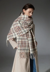 Close-up of thick multi-color plaid scarf with long fringe details and cozy texture