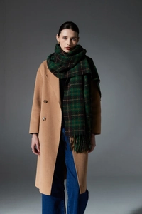 Winter scarf featuring red and green plaid patterns and tassels styled with a wool coat