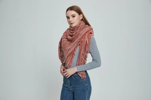 Detail of warm orange marl chunky knit scarf featuring soft fringe and thick texture