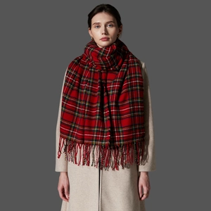 Detailed close-up of soft red plaid scarf texture with fringed edges for winter