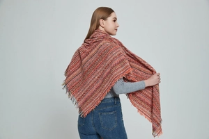 Detailed view of thick knit scarf with multi-color weave and long fringe edges