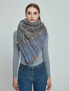 Détail d'une écharpe en tweed à carreaux colorés avec des bords à franges douces