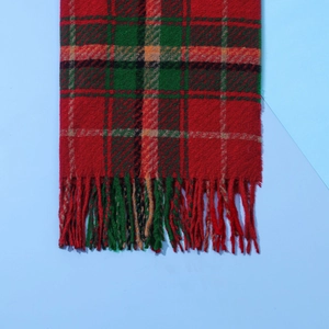 Detail shot of Christmas red and green plaid scarf texture and fringe craftsmanship