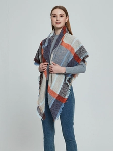Détail du châle à carreaux orange et bleu montrant la texture douce et les bords à franges