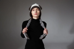 Detail showing plush panda ears and long faux fur tassels on a knitted winter hat