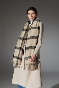 Détail d'une écharpe à carreaux classiques avec franges sur un manteau en laine beige