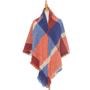 Détail d'une écharpe châle à carreaux bleu et orange avec des bords à franges