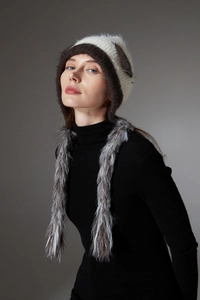 Detailed knit texture of a tricolor winter earflap hat with long faux fur accents