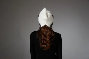 Detail of white faux fur knit hat showing plush texture and cat ear silhouette