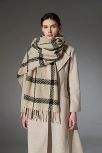 Détail du motif à carreaux doux et des longues franges sur une écharpe d'hiver épaisse