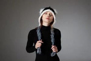 Detail of faux mink fur knit hat featuring cat ears and long braided tassels in tricolor