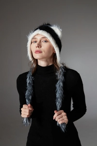Detailed close-up of the plush faux fur earflap hat with cat ears and long tassels