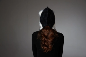 Detailed back view of a plush black and white faux fur cat ear hat for winter warmth