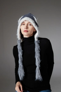 Detail of grey and white faux fur trapper hat with braided tassels for winter warmth