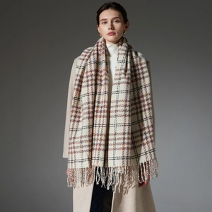 Elegant beige plaid winter scarf with fringe tassels shown on a model in studio lighting