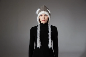 Detail of winter knit hat with brown cat ears and long white faux fur earflap braids